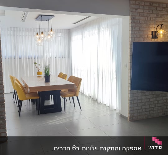 וילונות לבנים תלויים בחדר מואר עם שולחן אוכל